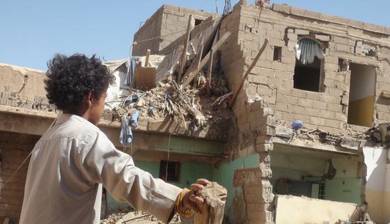 Child looking at the damage of war_War Child UK in Yemen_181229