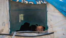 Kind dat uit het raam van hun tent gluurt in Lebanon_War Child_201006