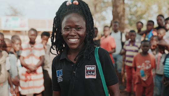 Ugandan facilitator helping out Burundian refugee children_War Child Uganda_190917