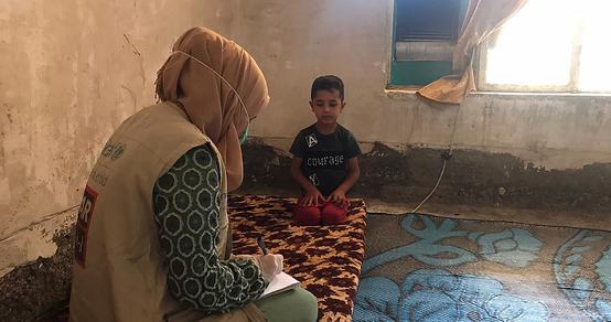 Corona response War Child_ employee helps child with mask_War Child Iraq_200603