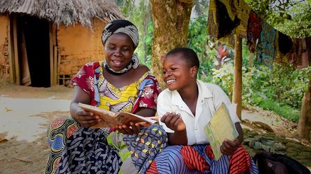 A girl in DRC studying with her mother