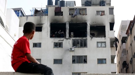 A child in Gaza looking at his bombed home