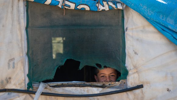 Kind dat uit het raam van hun tent gluurt in Lebanon_War Child_201006