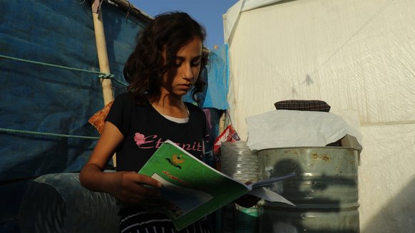 Girl reading - remote learning - War Child Holland in Iraq