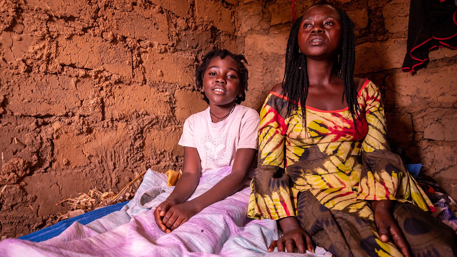 Mado and here mother from DR Congo are in their bed in a refugee camp in Uganda