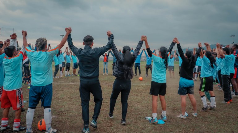 War Child Colombia Play it For Life participants standing in a group on a football field in a group